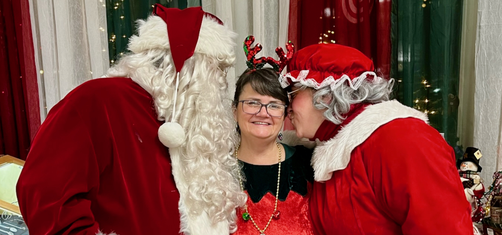 Santa & Mrs Clause kissing Lisa-Marie during Bright Night Bath 2023 in Bath, Maine